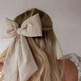 Kaxi Puffy Bow in taupe clipped into a low ponytail, back view