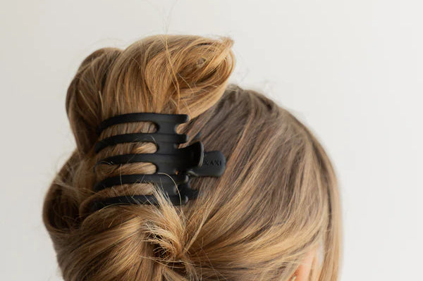 Kaxi Wide Lay Down Claw in black holding a twisted blonde updo, back view