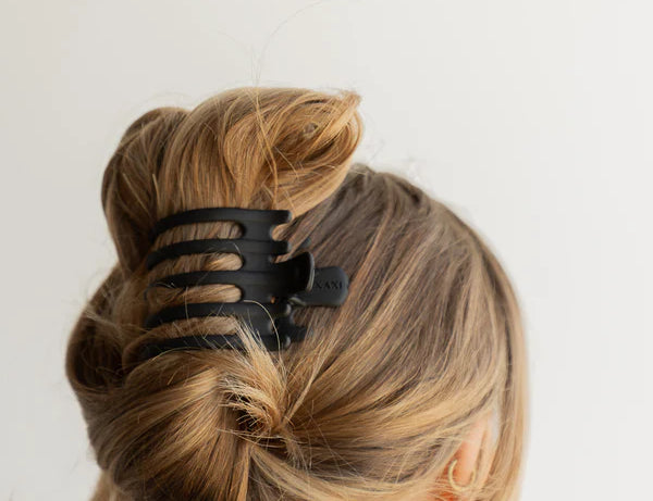 Kaxi Wide Lay Down Claw in black holding a twisted blonde updo, back view