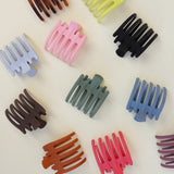Kaxi Wide Lay Down Claws in assorted colors scattered on white