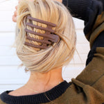 Kaxi Wide Lay Down Claw in taupe holding a blonde French twist, back view