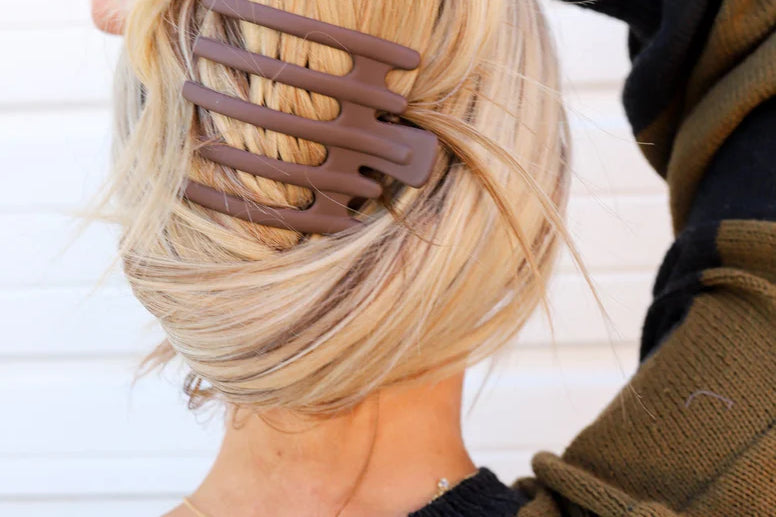 Kaxi Wide Lay Down Claw in taupe holding a blonde French twist, back view