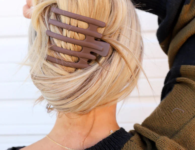 Kaxi Wide Lay Down Claw in taupe holding a blonde French twist, back view