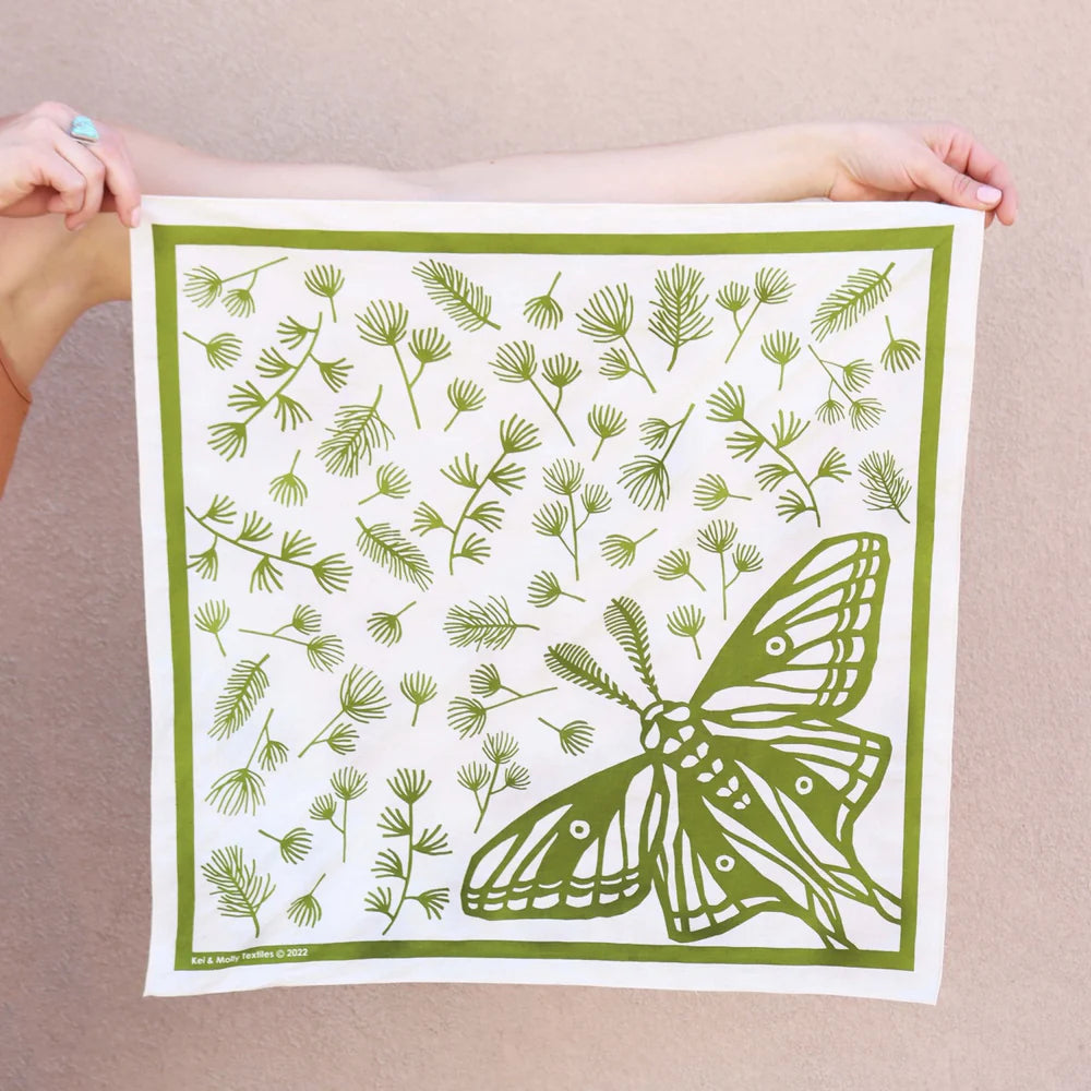 Kei & Molly Cotton Bandana in Moth, a white bandana with a green moth and pine sprig print