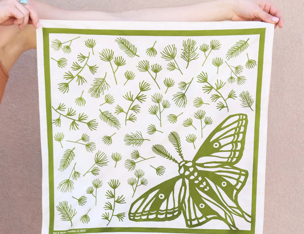 Kei & Molly Cotton Bandana in Moth, a white bandana with a green moth and pine sprig print