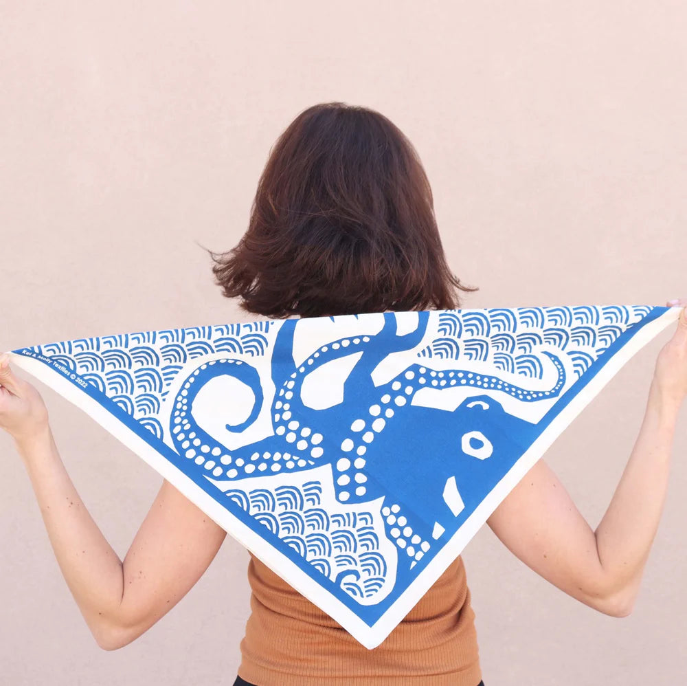 Woman holding a blue Kei & Molly Cotton Bandana with an octopus print open behind her back