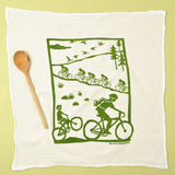 Kei & Molly Flour Sack Dish Towel in Bikes, a white towel with a green print of cyclists on a country road