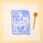 Kei & Molly Flour Sack Dish Towel in Grow Local Sky Blue, a white towel with a blue garden and house print