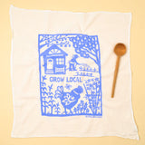 Kei & Molly Flour Sack Dish Towel in Grow Local Sky Blue, a white towel with a blue garden and house print