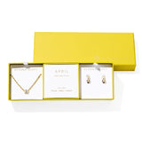 Kendra Scott Cailin Birthstone Gift Set for April in gold with White CZ, a pendant necklace and huggie earrings in a yellow gift box