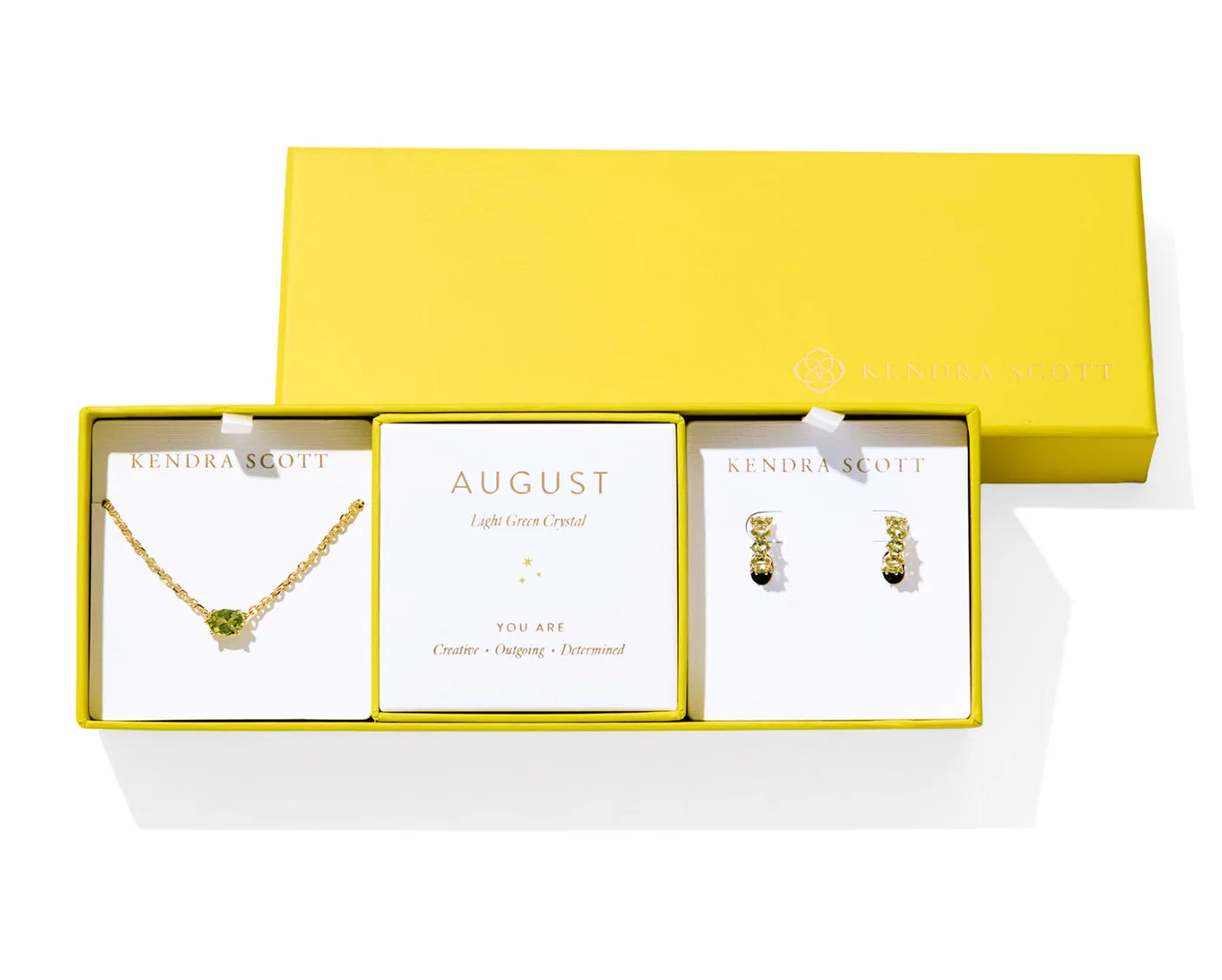Kendra Scott Cailin Birthstone Gift Set for August in gold with Light Green Crystal, a pendant necklace and huggie earrings in a yellow gift box
