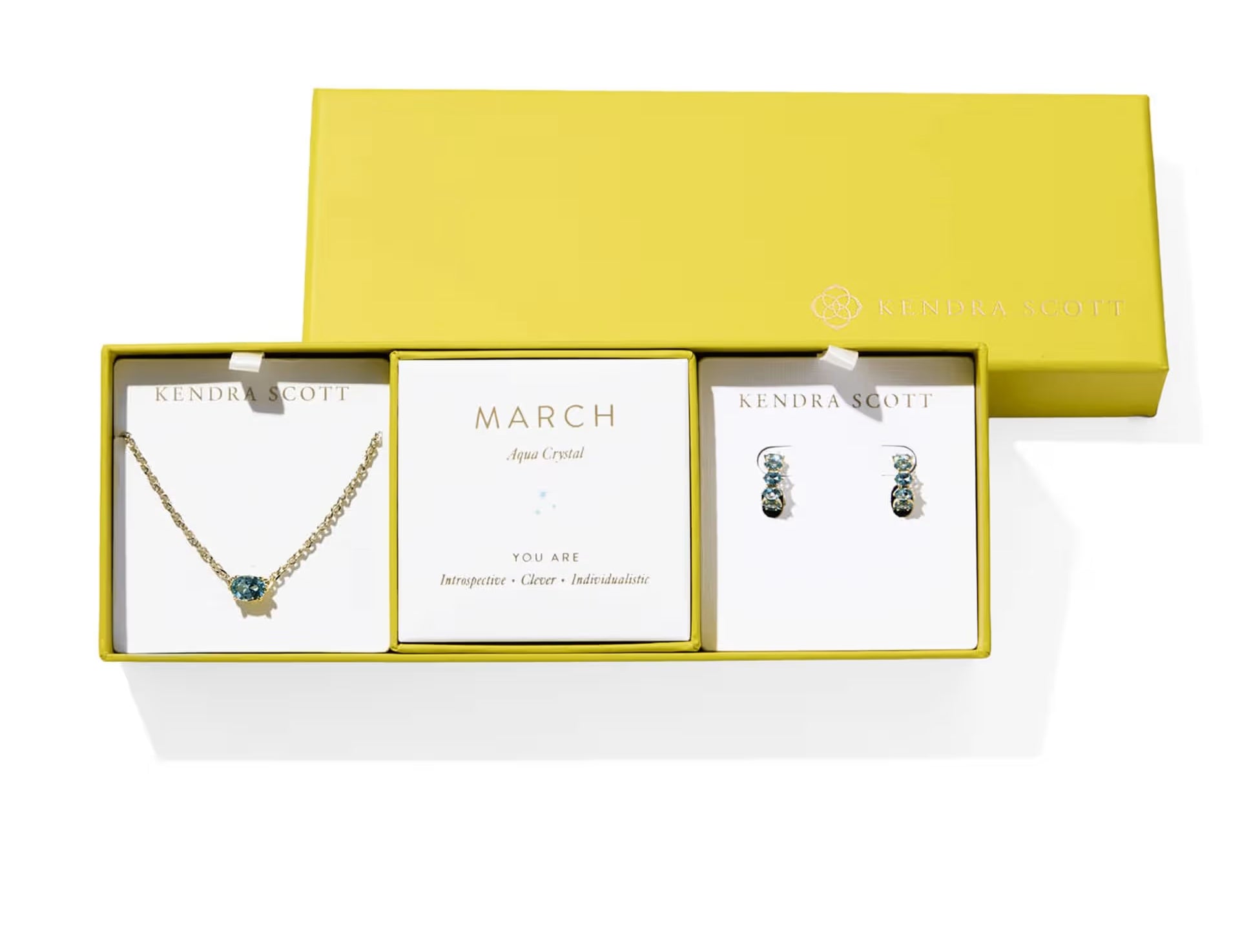 Kendra Scott Cailin Birthstone Gift Set for March in gold with Aqua Crystal, a pendant necklace and huggie earrings in a yellow gift box