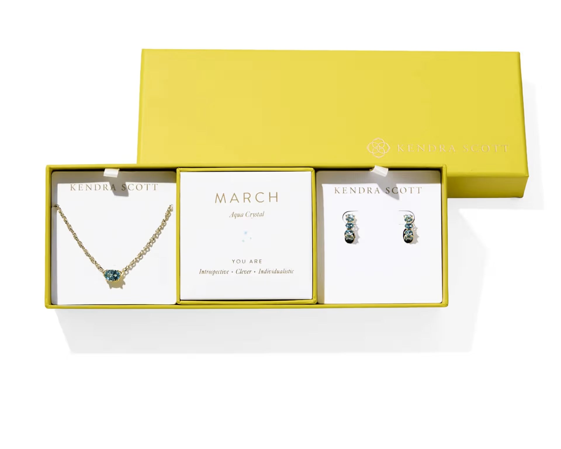 Kendra Scott Cailin Birthstone Gift Set for March in gold with Aqua Crystal, a pendant necklace and huggie earrings in a yellow gift box