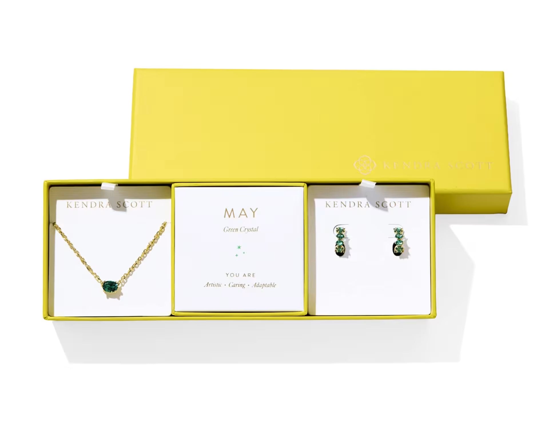 Kendra Scott Cailin Birthstone Gift Set for May in gold with Green Crystal, a pendant necklace and huggie earrings in a yellow gift box
