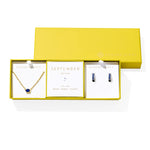 Kendra Scott Cailin Birthstone Gift Set for September in gold with Blue Crystal, a pendant necklace and huggie earrings in a yellow gift box