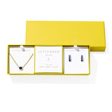 Kendra Scott Cailin Birthstone Gift Set for September in gold with Blue Crystal, a pendant necklace and huggie earrings in a yellow gift box