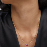 Woman in a black top wearing the Kendra Scott Cailin Gold Birthday Pendant Necklace in Burgundy Crystal