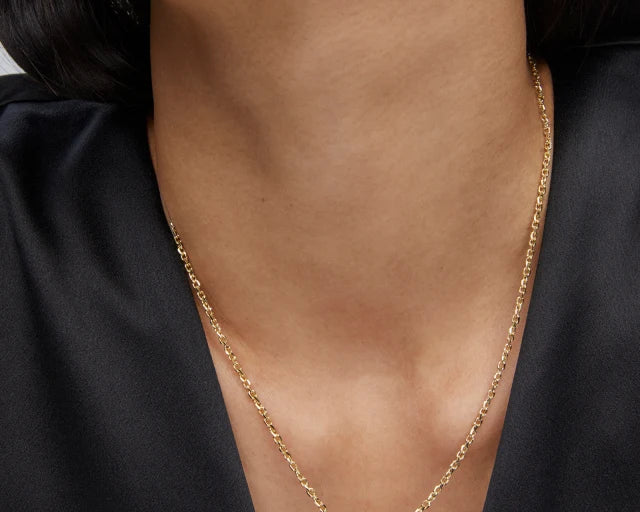 Woman in a black top wearing the Kendra Scott Cailin Gold Birthday Pendant Necklace in Burgundy Crystal