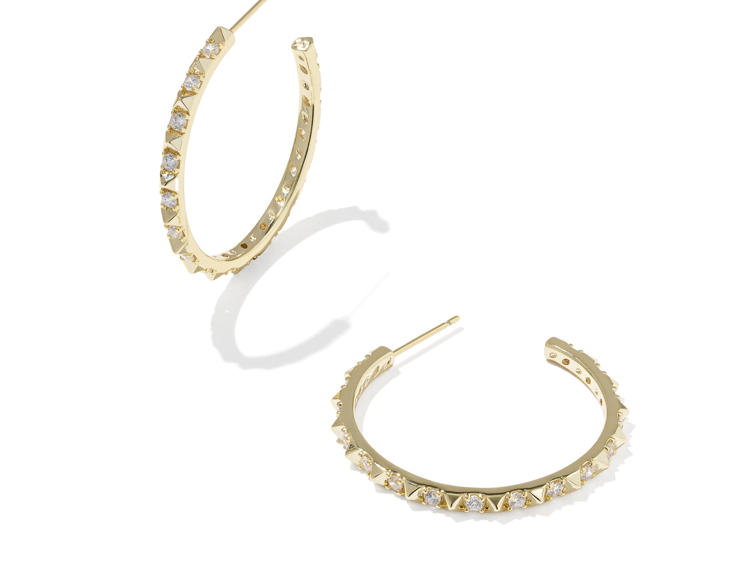 Kendra Scott Fate Hoop Earrings in gold, a pair of open hoops lined with small spikes and cubic zirconia
