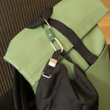 Kikkerland Dual Clip Buddy clipped to a green backpack strap