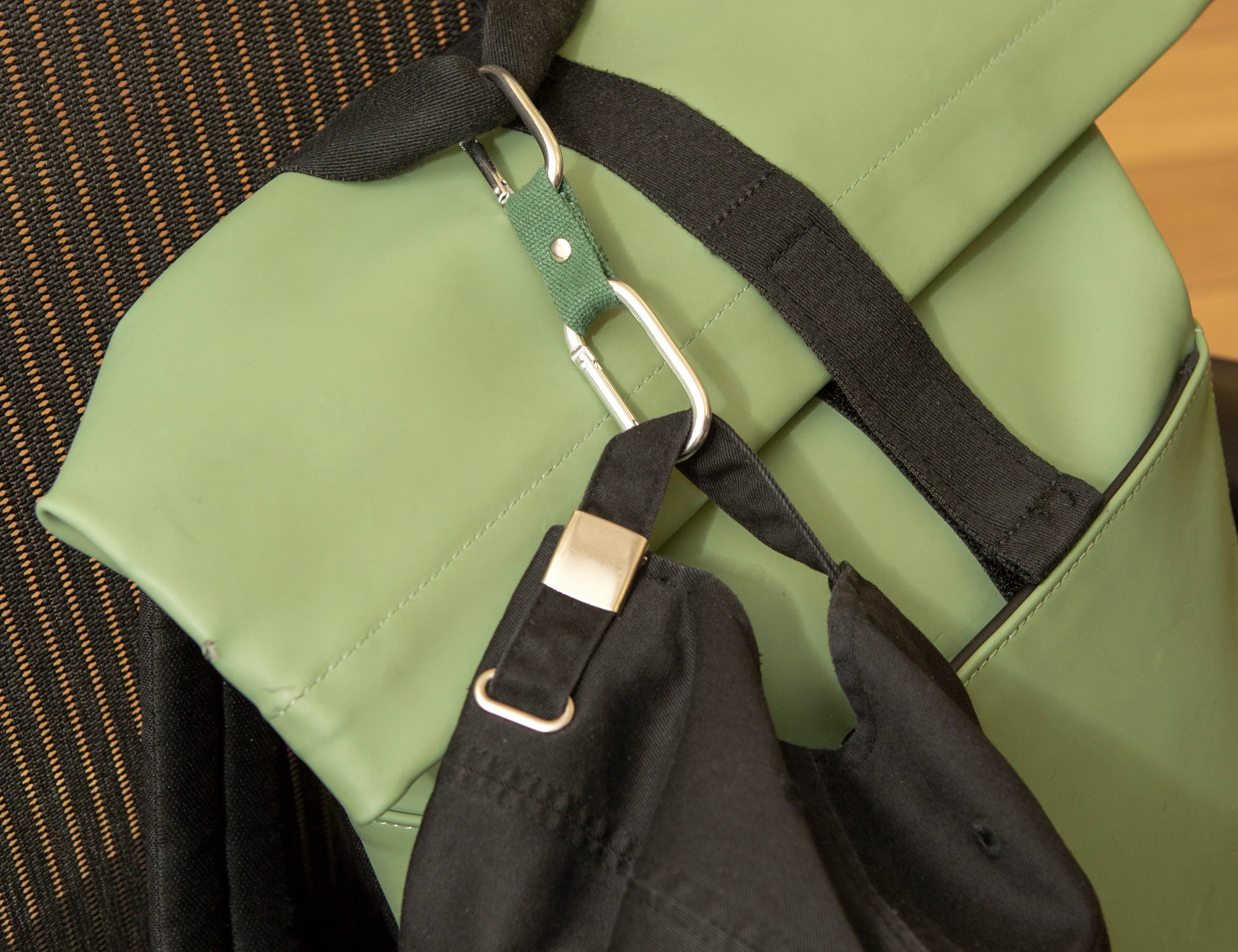 Kikkerland Dual Clip Buddy clipped to a green backpack strap