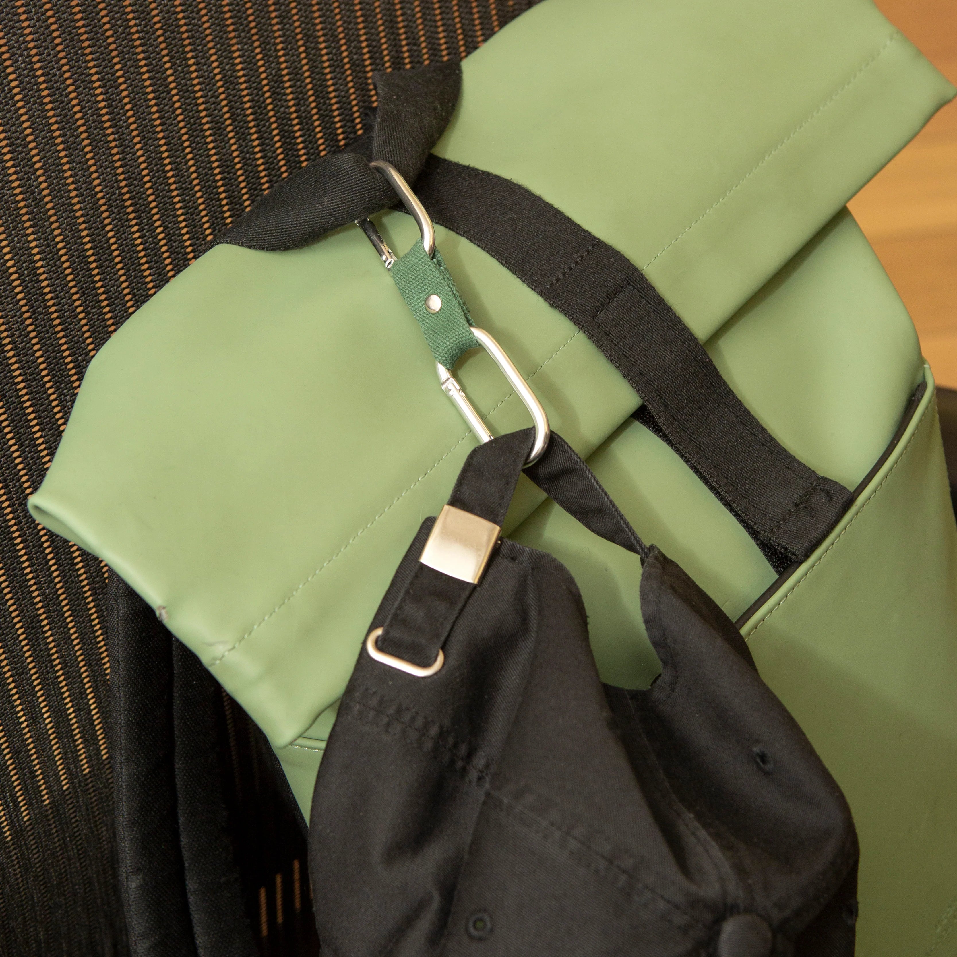 Kikkerland Dual Clip Buddy clipped to a green backpack strap