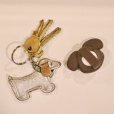 Kikkerland Kobe Air Tag Holder beside keys and a dog keychain
