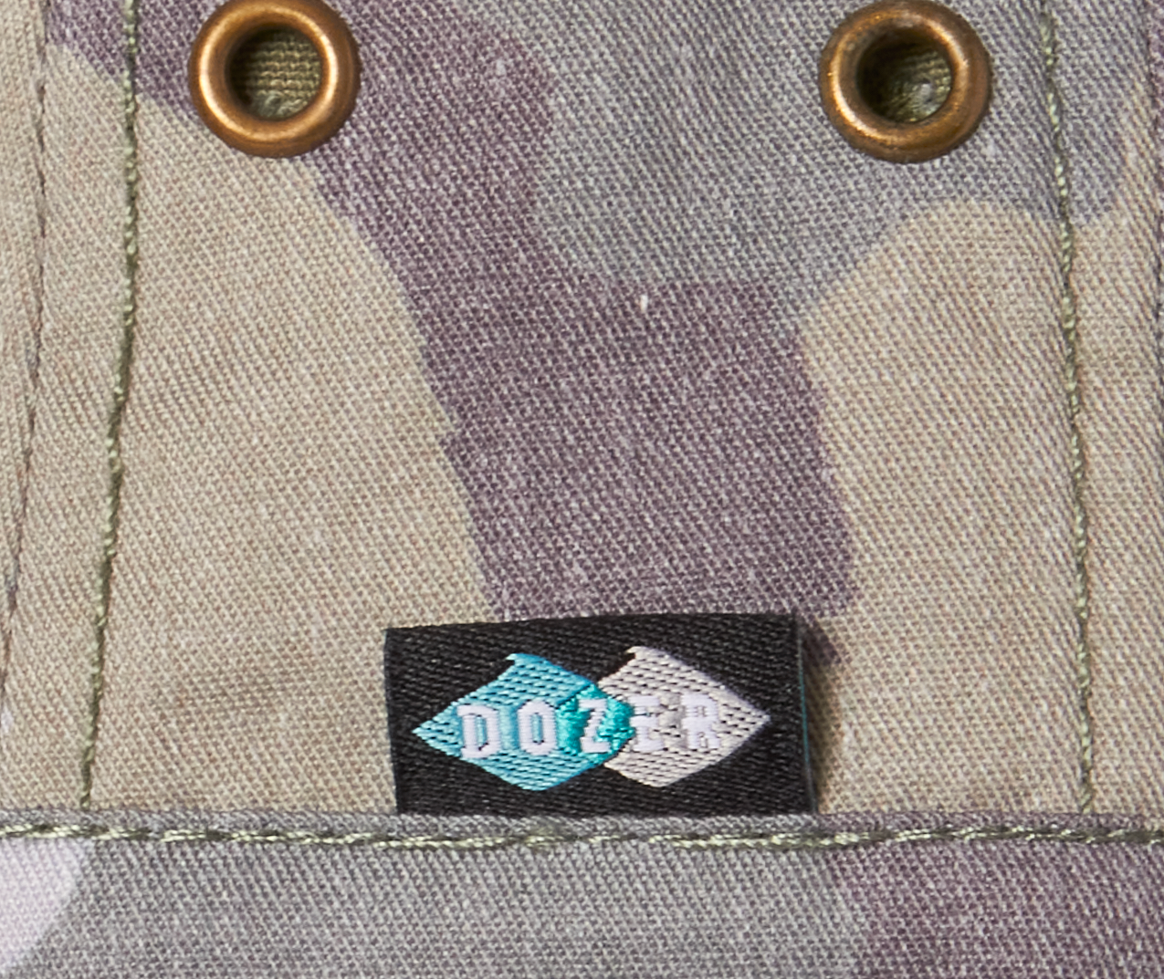 Close-up of the brass eyelets and Dozer label on the Kooringal Boys Bucket Hat in Camo