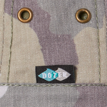 Close-up of the brass eyelets and Dozer label on the Kooringal Boys Bucket Hat in Camo