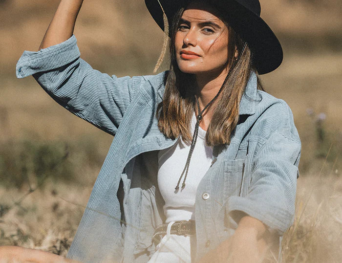 Woman in a field wearing the Kooringal Women's Selwyn Fedora in Black with a denim jacket