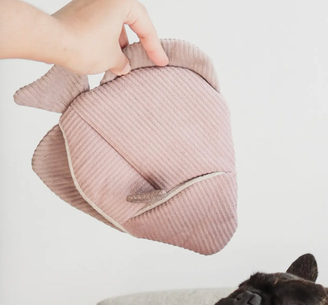 Lambwolf Collective Angel Fish Dog Toy in pink corduroy held in a hand showing the treat pocket