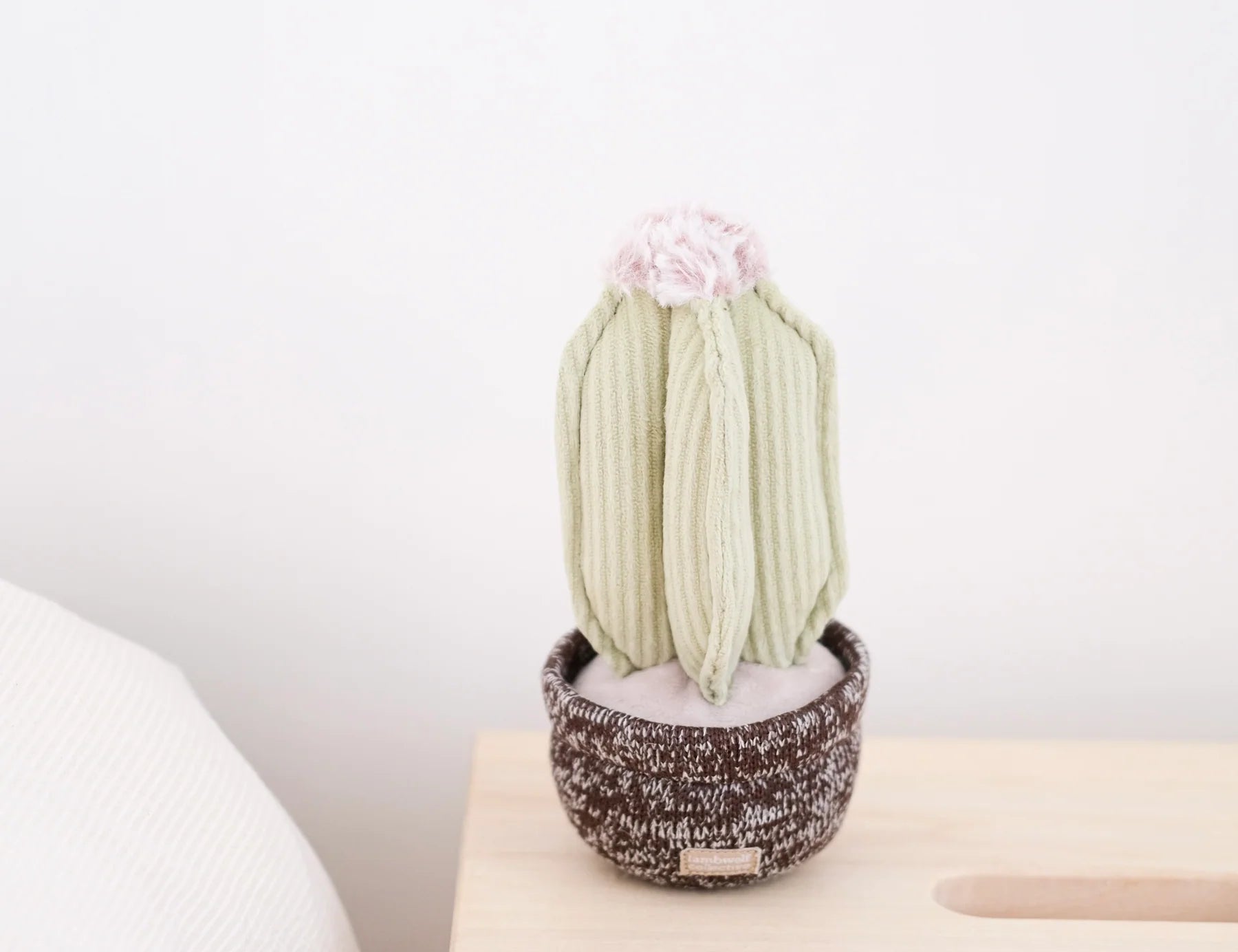 Lambwolf Collective Cactus Dog Toy, a pale green corduroy cactus in a brown knit pot on a side table