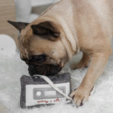 French bulldog chewing the Lambwolf Collective Cassette Dog Toy on a fluffy rug