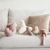 Lambwolf Collective Nounou Dogwood Squeakers Dog Toys in blush and cream on a gray couch