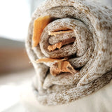Close-up of treats tucked into the rolled tweed shell of the Lambwolf Collective Snail Snuffle Dog Toy
