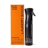 Laundry Sauce Fabric Refresher Spray in Italian Bergamot, a black spray bottle beside its orange box