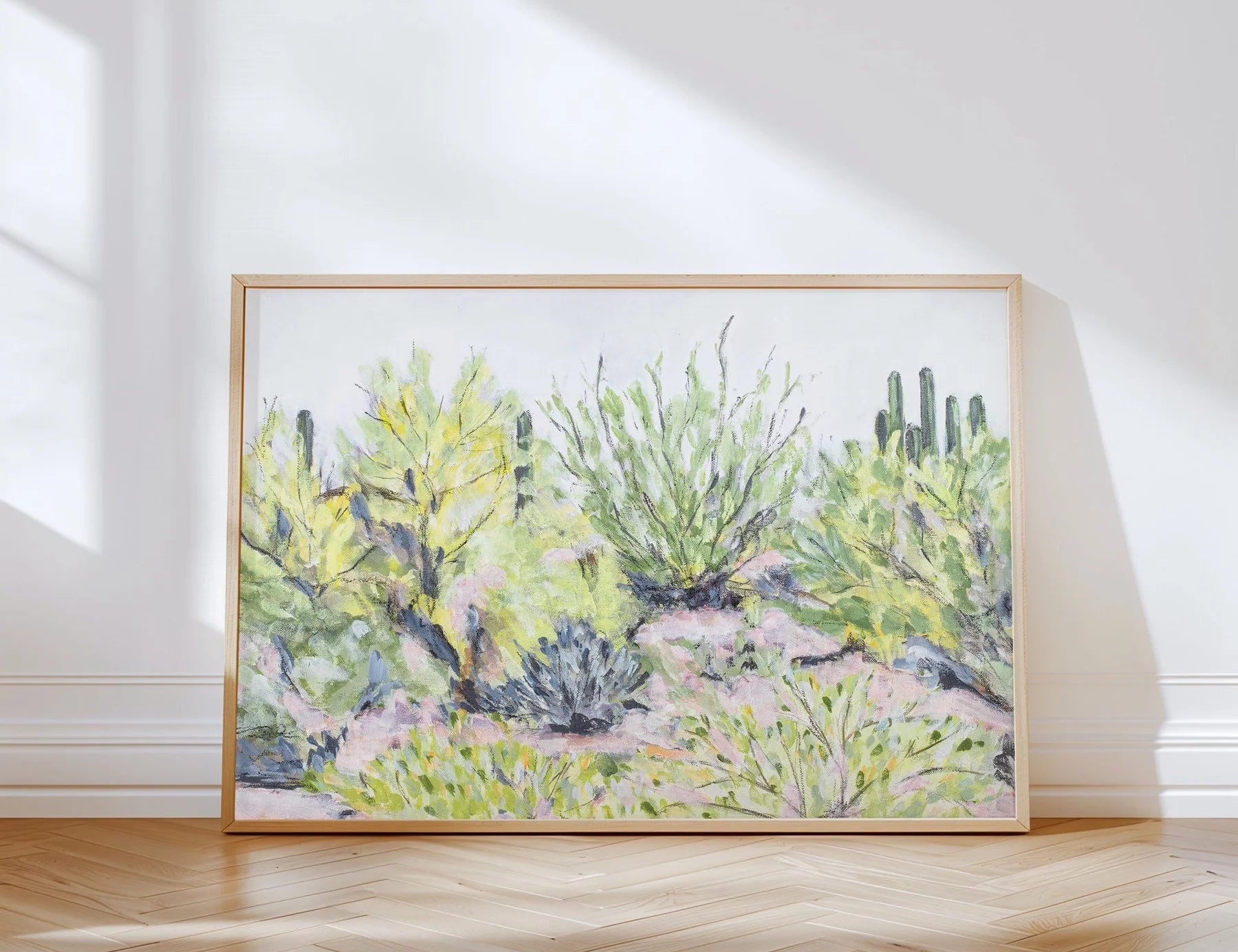 Laurie Anne Art Desert Plants Fine Art Print in a thin wood frame leaning against a wall in sunlight