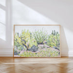 Laurie Anne Art Desert Plants Fine Art Print in a thin wood frame leaning against a wall in sunlight