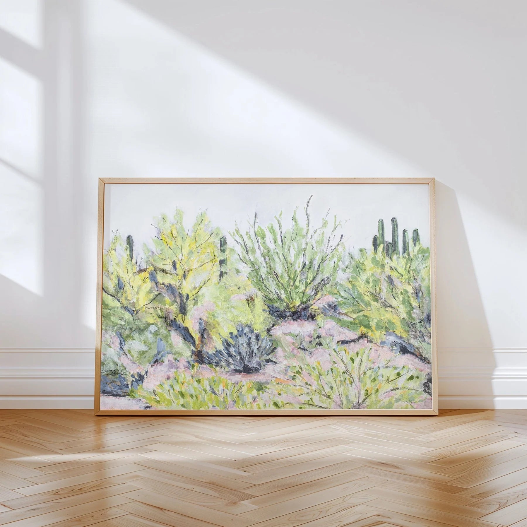 Laurie Anne Art Desert Plants Fine Art Print in a thin wood frame leaning against a wall in sunlight