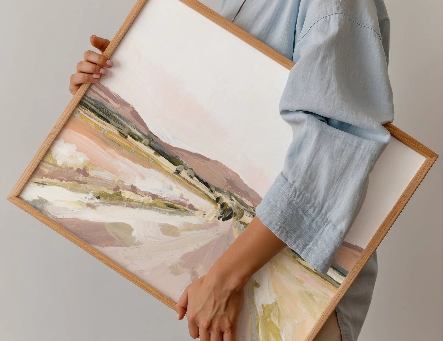 Person in a blue shirt holding the framed Laurie Anne Art Desert Road Fine Art Print