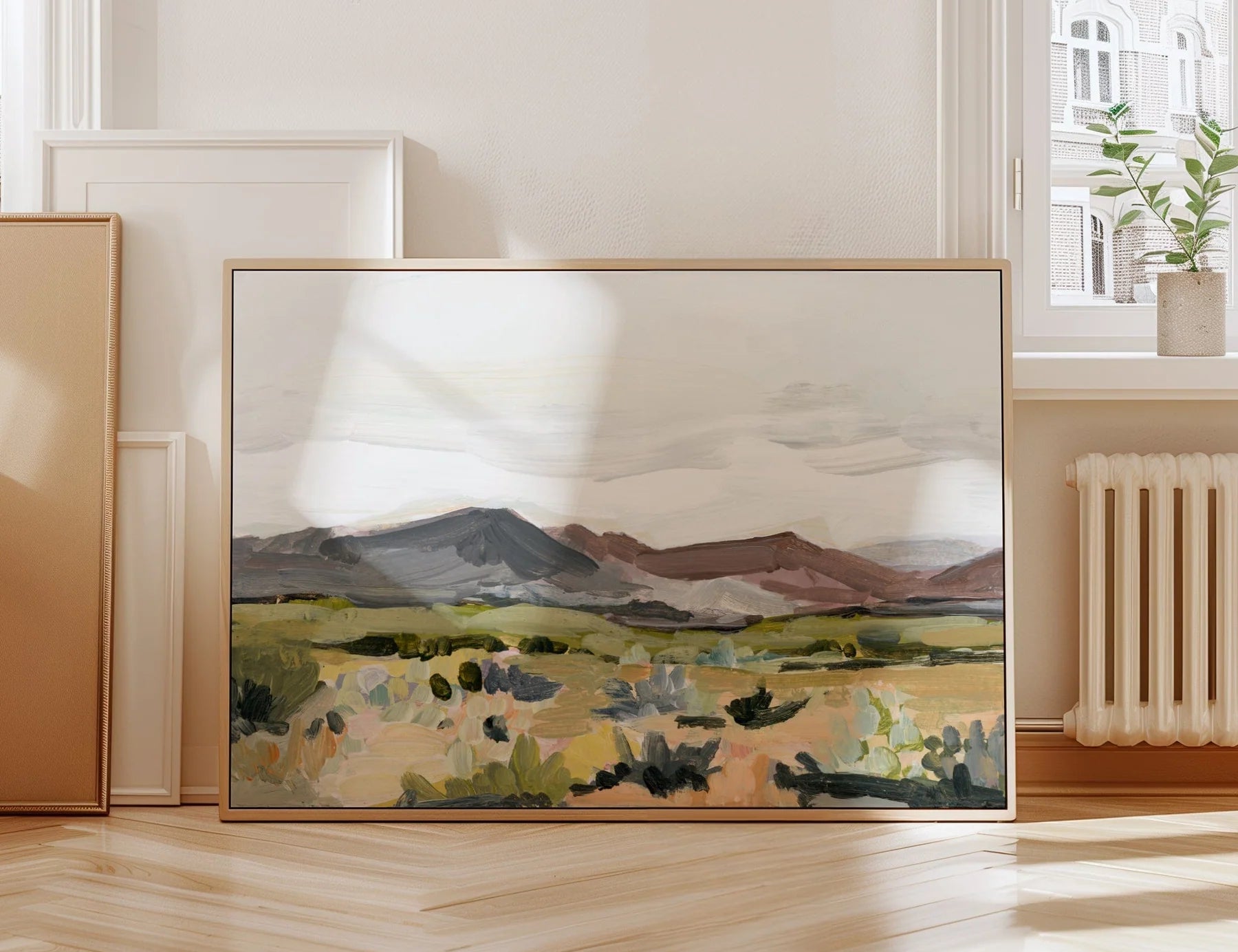 Laurie Anne Art Mauve Desert Fine Art Print in a wood frame leaning against a wall in a sunlit room