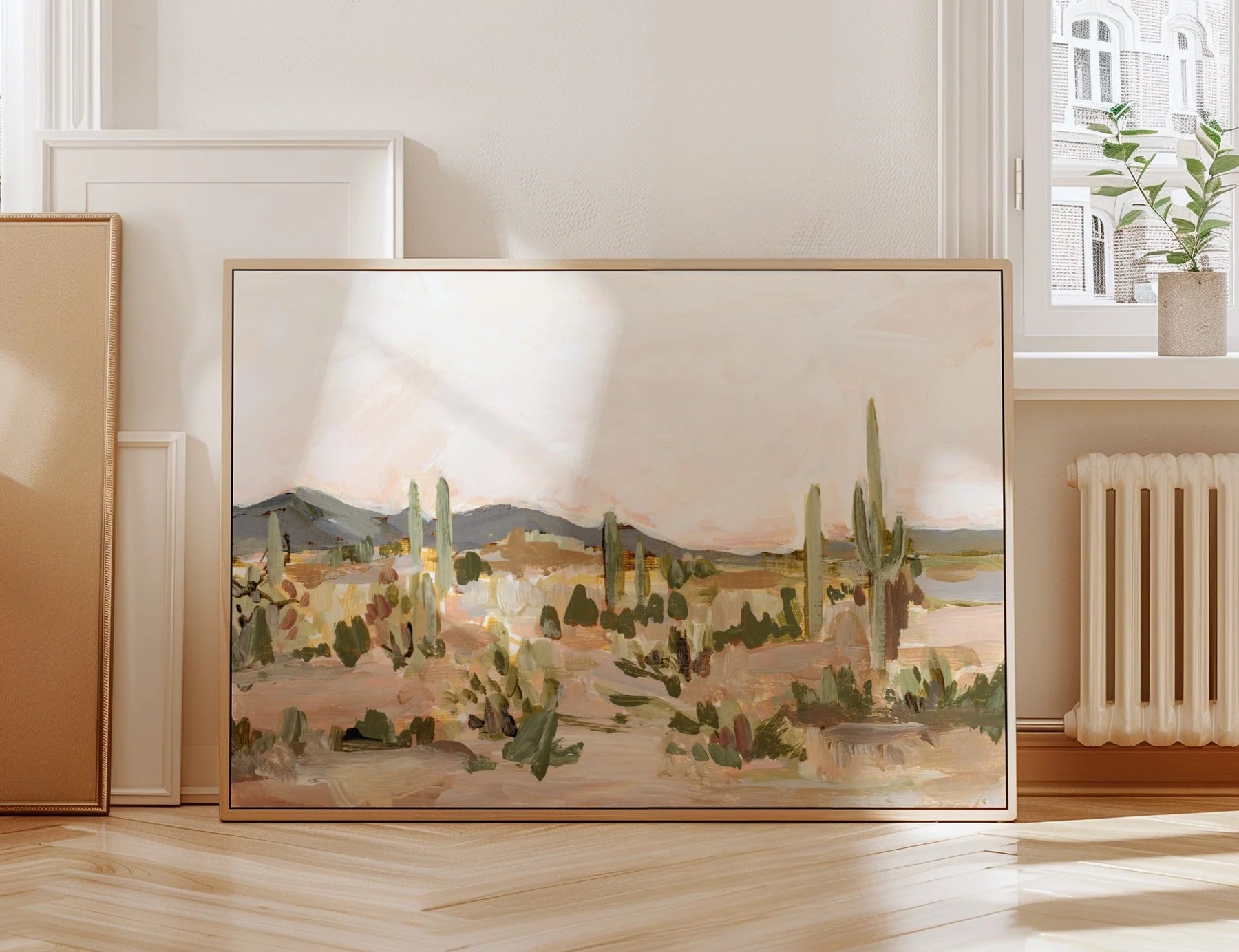 Laurie Anne Art Saguaro Fine Art Print in a wood frame leaning against a wall on a herringbone floor