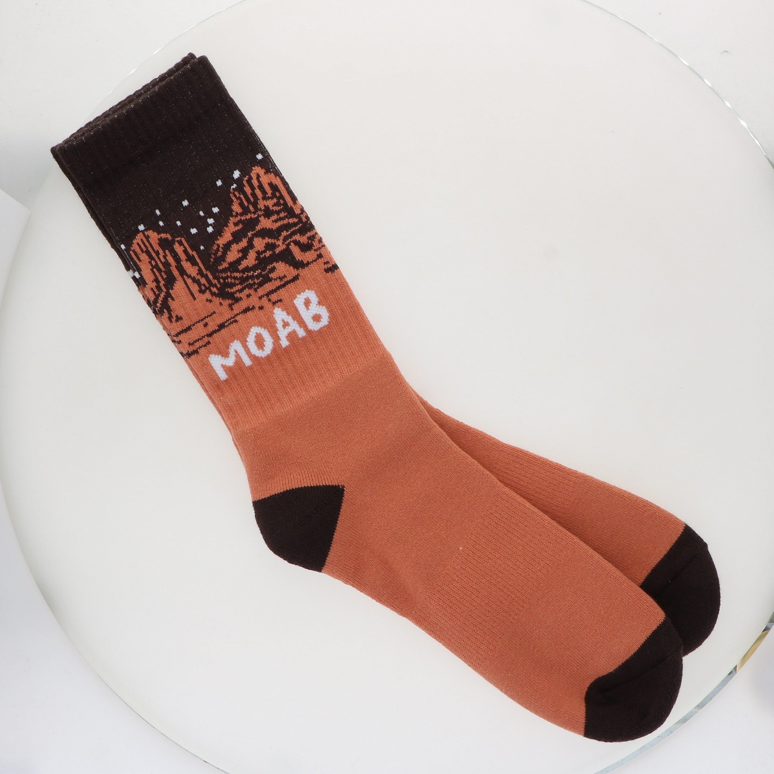 Locale Desert Night Sky Socks, rust orange crew socks with a black starry-sky cuff reading Moab