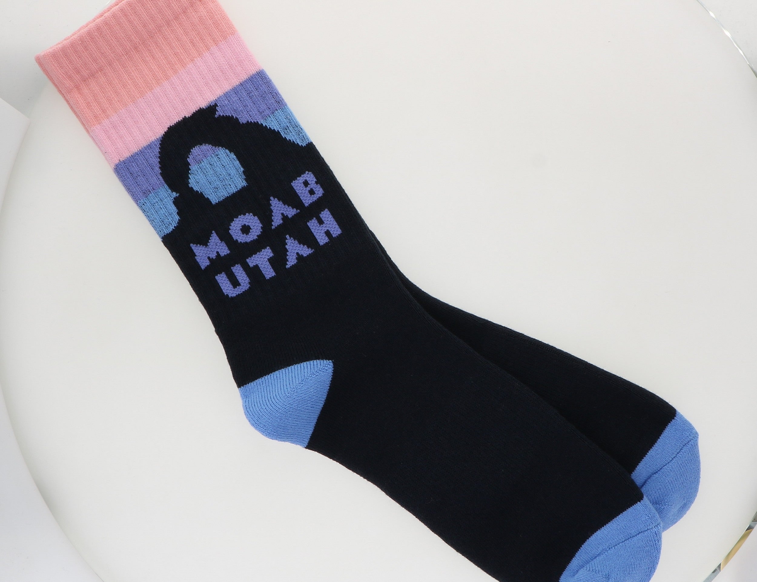Locale Soft Sunset Moab Socks, black crew socks with a pink and blue sunset and an arch reading Moab Utah