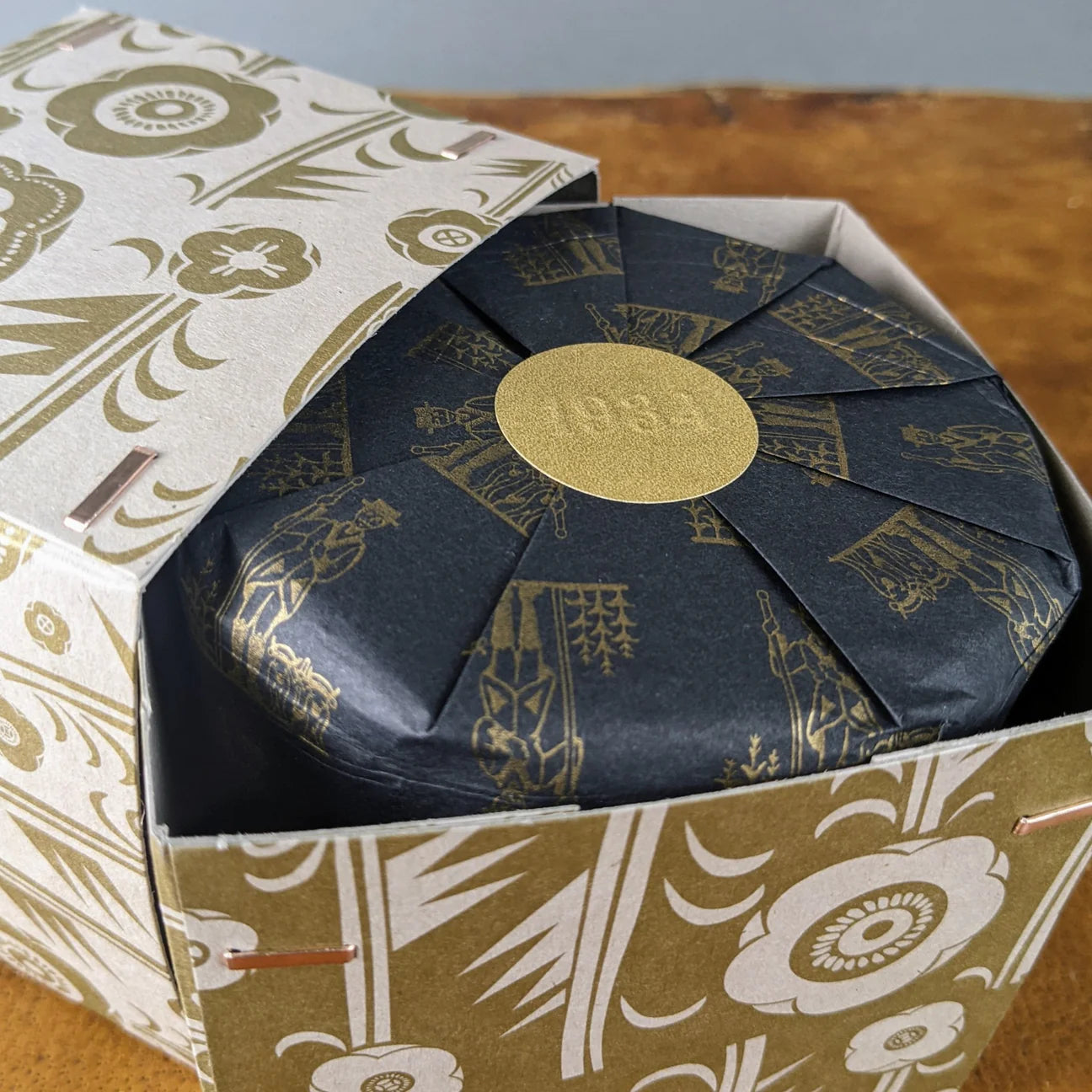 Los Poblanos Herbal Bug Repellent candle box with a gold and black botanical print