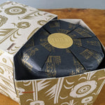Los Poblanos Herbal Bug Repellent candle box with a gold and black botanical print