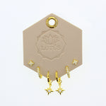 Lotus Studio Gold Trio Earrings in Amelia, star studs, pave huggies and star drop hoops on a Lotus card
