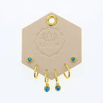 Lotus Studio Gold Trio Earrings in Andy, turquoise studs, gold huggies and turquoise drop hoops on a Lotus card