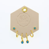 Lotus Studio Gold Trio Earrings in Andy, turquoise studs, gold huggies and turquoise drop hoops on a Lotus card