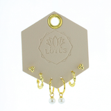 Lotus Studio Gold Trio Earrings in Audrey, dot studs, pave huggies and pearl drop hoops on a Lotus card